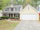 Charming two-story home with a well-maintained front lawn and attached two car garage at 1972 Ashwood Grove Dr, Snellville, GA 30078