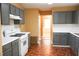 Bright kitchen showcasing grey cabinets, white countertops, and an oven range, with a glimpse into the adjacent living space at 1972 Ashwood Grove Dr, Snellville, GA 30078