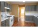 Kitchen featuring grey cabinets, white countertops, and hardwood floors with appliances including a range, oven, and dishwasher at 1972 Ashwood Grove Dr, Snellville, GA 30078