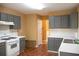 Well-lit kitchen featuring gray cabinets, white appliances, and white countertops at 1972 Ashwood Grove Dr, Snellville, GA 30078