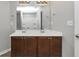 Bathroom vanity featuring dual sinks, dark cabinets, and a large mirror at 222 Alton Cir, Villa Rica, GA 30180