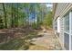 View of backyard featuring a small concrete patio, with a wooded area on a sunny day at 3936 Toccoa Falls Dr, Duluth, GA 30097