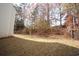 Manicured backyard featuring lush lawn and privacy from trees, adjacent to home's siding at 3936 Toccoa Falls Dr, Duluth, GA 30097