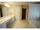 Well-lit bathroom with dual vanity sinks, tile floors, and a separate shower and tub at 3936 Toccoa Falls Dr, Duluth, GA 30097