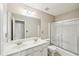 Bright bathroom featuring a double sink vanity with a large mirror and a shower-tub combination with sliding glass doors at 3936 Toccoa Falls Dr, Duluth, GA 30097