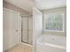 Bright bathroom showcasing a soaking tub beside a shower and a neutral color scheme at 3936 Toccoa Falls Dr, Duluth, GA 30097