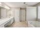Bathroom featuring double sinks, large mirror, soaking tub, walk-in shower, and neutral paint at 3936 Toccoa Falls Dr, Duluth, GA 30097