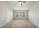 Neutral bedroom features plush carpet, vaulted ceiling with fan, and a window letting in natural light at 3936 Toccoa Falls Dr, Duluth, GA 30097
