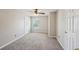 Bright bedroom with neutral walls, carpet, and a ceiling fan; multiple doors and good natural light at 3936 Toccoa Falls Dr, Duluth, GA 30097
