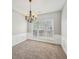 A dining room with plush carpet, large window, and wainscotting details at 3936 Toccoa Falls Dr, Duluth, GA 30097