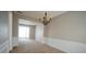 Dining room with neutral walls and carpet plus wainscotting and a chandelier at 3936 Toccoa Falls Dr, Duluth, GA 30097