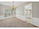 A dining room with plush carpet, large window, wainscotting, and access to kitchen at 3936 Toccoa Falls Dr, Duluth, GA 30097