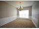 Dining room featuring wainscotting and a chandelier with neutral paint and carpet at 3936 Toccoa Falls Dr, Duluth, GA 30097