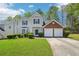 Charming two-story home features a two-car garage, manicured lawn, and classic architectural details at 3936 Toccoa Falls Dr, Duluth, GA 30097