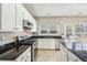 Open kitchen featuring granite countertops, stainless steel appliances, white cabinetry, and tile flooring at 3936 Toccoa Falls Dr, Duluth, GA 30097