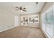 Spacious living room with carpet, a ceiling fan, natural light, and view into the connected eat-in kitchen at 3936 Toccoa Falls Dr, Duluth, GA 30097