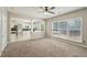 Cozy living room with large windows, neutral paint, ceiling fan, and an open view of the kitchen area at 3936 Toccoa Falls Dr, Duluth, GA 30097