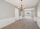 An open-concept living room and dining area features plush carpet and wainscotting details at 3936 Toccoa Falls Dr, Duluth, GA 30097
