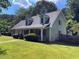Well-maintained home with dormer windows, green lawn, and mature trees at 728 Slew Ave, Lawrenceville, GA 30043