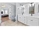 Double vanity bathroom with tile floors, white cabinets, and view into main bedroom at 130 Arbor Cove Way, Stockbridge, GA 30281