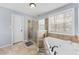 Bathroom featuring a glass enclosed shower and a soaking tub under a window bringing in lots of light at 130 Arbor Cove Way, Stockbridge, GA 30281