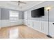 Bedroom with hardwood floors, a ceiling fan, wainscoting, and a large window providing ample natural light at 130 Arbor Cove Way, Stockbridge, GA 30281