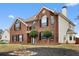 Inviting two-story brick home with a manicured front yard and classic architectural design, set on a sunny day at 130 Arbor Cove Way, Stockbridge, GA 30281