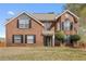Charming two-story brick home featuring a well-manicured front lawn and traditional architectural details at 130 Arbor Cove Way, Stockbridge, GA 30281