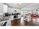 Modern kitchen with stainless steel appliances, an island, and hardwood floors open to the living area at 130 Arbor Cove Way, Stockbridge, GA 30281