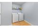 Functional laundry room with hardwood floors, washer, dryer, and shelving for convenient storage at 130 Arbor Cove Way, Stockbridge, GA 30281