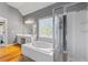 A bright bathroom with wood floors features a soaking tub and glass enclosed shower at 3986 Harmony Walk Se Way, Smyrna, GA 30082