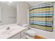 Bright bathroom featuring a white vanity, mirror, and a bathtub with a colorful striped shower curtain at 3986 Harmony Walk Se Way, Smyrna, GA 30082