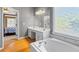 Bathroom featuring wood floors, a soaking tub, and a view into the bedroom at 3986 Harmony Walk Se Way, Smyrna, GA 30082