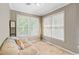 Bedroom with a couch, a window, light tan walls and carpet, plus a small wooden ladder shelf at 3986 Harmony Walk Se Way, Smyrna, GA 30082