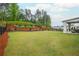Landscaped backyard with lush green lawn, mature trees, a black fence, and covered patio at 1011 Ridgeview Rd, Woodstock, GA 30188