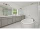 Bright bathroom features a soaking tub, double sink vanity, and tiled floors, offering a luxurious and functional space at 1011 Ridgeview Rd, Woodstock, GA 30188