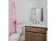 Bright bathroom features a vanity with a white countertop, wood cabinets, and a floral shower curtain at 1011 Ridgeview Rd, Woodstock, GA 30188