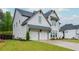 Well maintained two-story white brick home with a two car garage, green lawn, and landscaping at 1011 Ridgeview Rd, Woodstock, GA 30188