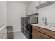 Well-organized laundry room featuring modern washer and dryer set, storage cabinets, and a practical sink area at 1011 Ridgeview Rd, Woodstock, GA 30188