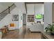 Open-concept living room with hardwood floors, staircase, fireplace, custom built-ins, and plenty of natural light at 1011 Ridgeview Rd, Woodstock, GA 30188