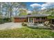 Charming backyard with a brick house, a fire pit, and lush landscaping for outdoor enjoyment at 1245 Briar Hills Ne Dr, Atlanta, GA 30306
