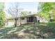 Large, grassy backyard with mature trees surrounding a classic brick home at 558 Larchmont Nw Dr, Atlanta, GA 30318