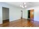 Spacious bedroom with hardwood floors, modern light fixture, and easy access to other rooms at 558 Larchmont Nw Dr, Atlanta, GA 30318
