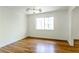 Bright bedroom with hardwood floors, ample natural light, and modern light fixture at 558 Larchmont Nw Dr, Atlanta, GA 30318