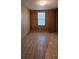 Bedroom with wood-look floors, light from window and wood paneling at 1406 High Sierra Dr, Lawrenceville, GA 30043
