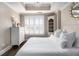 Bright bedroom with wood floors, white shutters, tray ceiling, and a decorative chandelier at 2277 Peachtree Rd # 503, Atlanta, GA 30309
