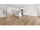 Bright open concept living area showcasing sleek wood flooring and a modern kitchen with a center island, offering a welcoming space at 2831 Centerville Rosebud Rd, Snellville, GA 30039