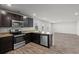 Open-concept kitchen with stainless appliances, granite counters, dark cabinets and views into the living area at 3038 Chris Cir, Villa Rica, GA 30180