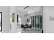 Modern dining room with glass enclosed wine cellar, sleek table and a modern chandelier at 4031 Oak Forest Cir, Marietta, GA 30062