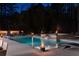 A luxurious backyard featuring a pool, spa, lounge chairs, and ambient lighting at 4031 Oak Forest Cir, Marietta, GA 30062